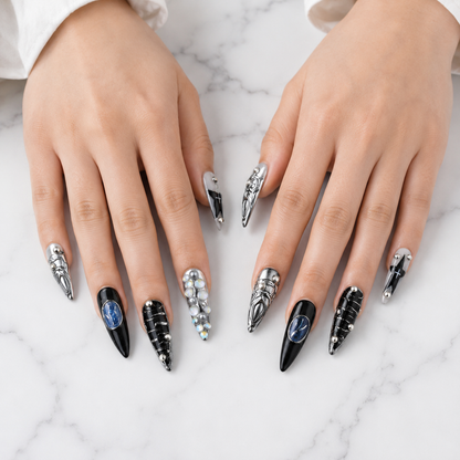 Black silver chrome press on nails displayed on both hands over white marble