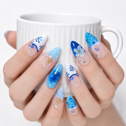 Blue ocean press on nails worn on hands holding a white coffee cup