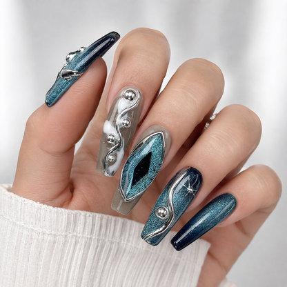 Blue teal cat eye chrome 3D press on nails with metallic silver accents on hand, luxury handmade reusable fake nails, white background.