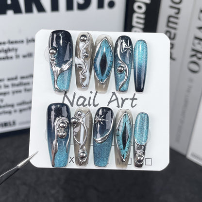 Blue teal cat eye chrome handmade press on nails displayed on both hands over a white marble table, reusable luxury fake nails.