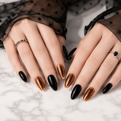Both hands wearing luxury black and gold chrome press on nails on white marble, handcrafted glossy almond fake nails with reusable premium design.