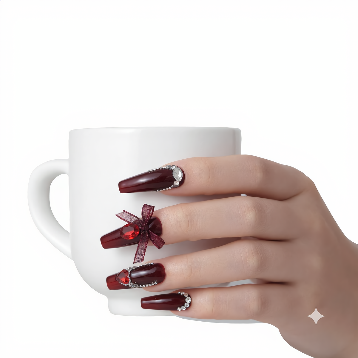 Burgundy rhinestone press on nails with 3D bow holding a white coffee cup