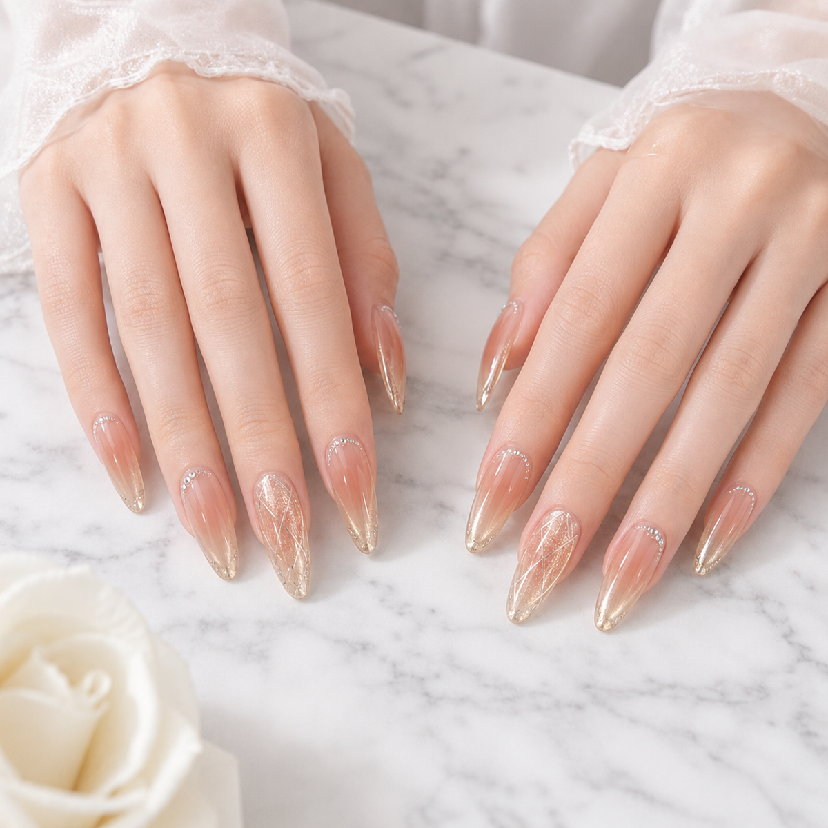 Champagne almond press on nails displayed on both hands over white marble