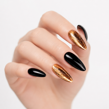 Close-up of black and gold chrome almond press on nails with reflective metallic finish, handcrafted reusable fake nails for women.