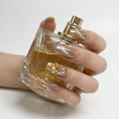 Elegant gold French press on nails with crystal accents and nude shimmer