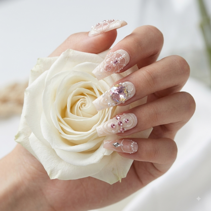 Elegant pink crystal press on nails worn on hand holding a white rose