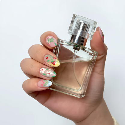 Floral almond press on nails on hand holding luxury perfume bottle
