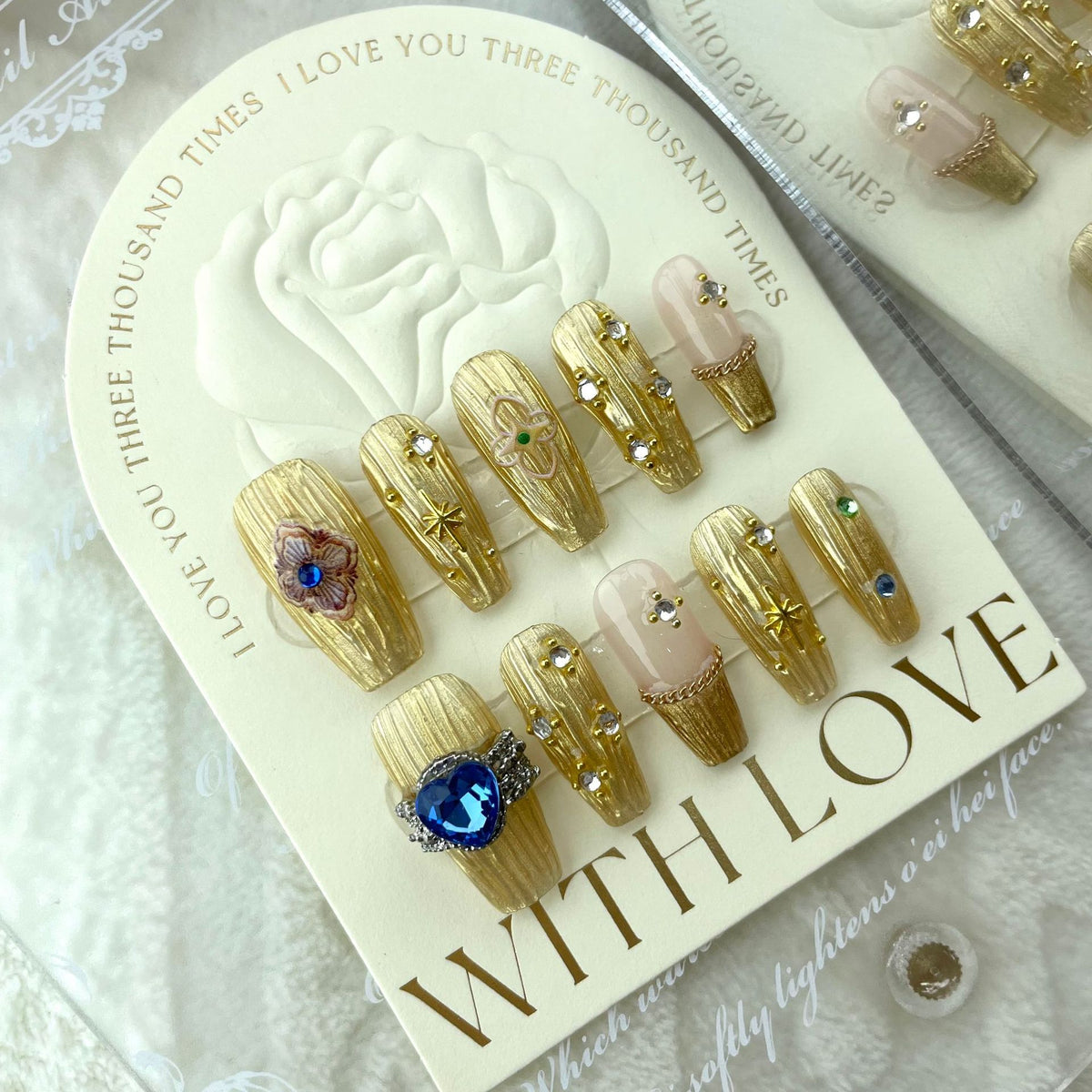 Gold press on nails with blue gemstone and luxury metallic details