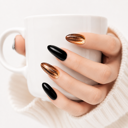 Luxury black and gold chrome press on nails holding a white coffee cup, glossy handmade almond fake nails with premium mirror finish.