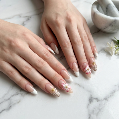 Luxury floral press on nails displayed on both hands over white marble