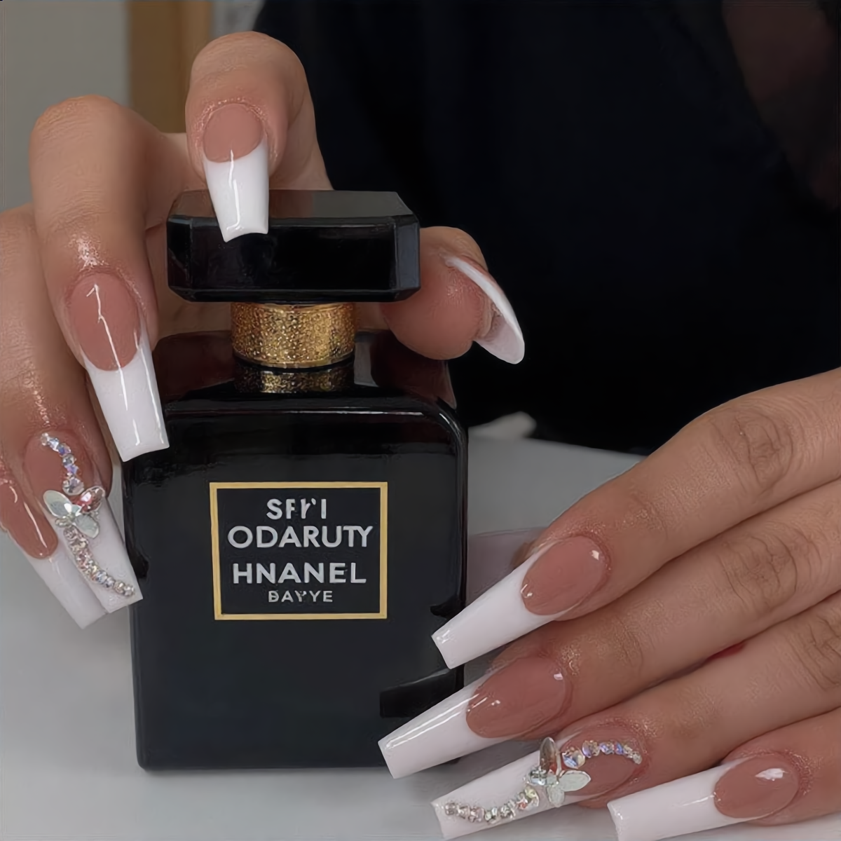 Luxury white French butterfly press on nails with crystal details styled with perfume