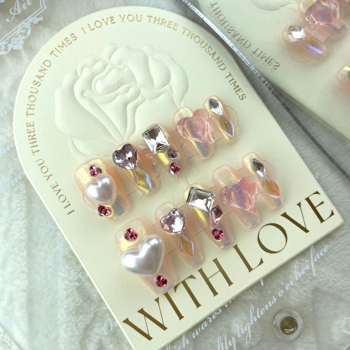 Nude crystal press on nails with pink hearts and rhinestone decorations