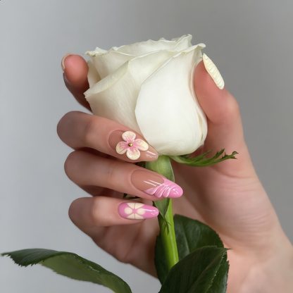 Pastel pink floral press on nails with 3D flower design holding a white rose