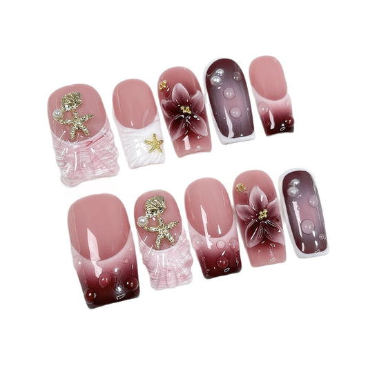 Pink Floral Ocean Press On Nails holding a luxury perfume bottle