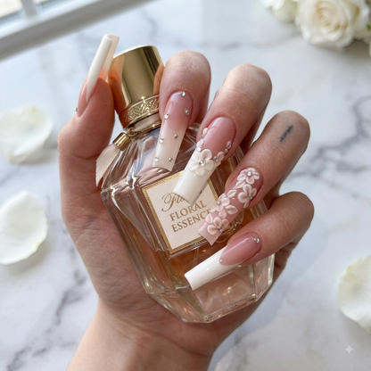 Pink French press on nails with 3D flower and crystal accents holding perfume