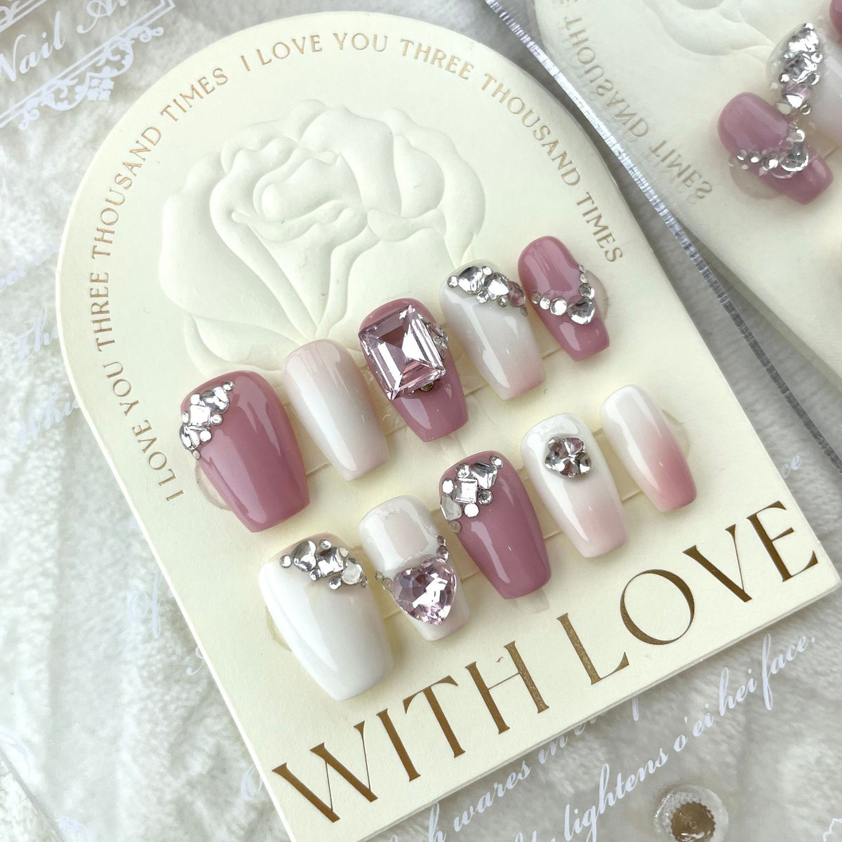 Pink French tip press on nails with white tips and rhinestone accents