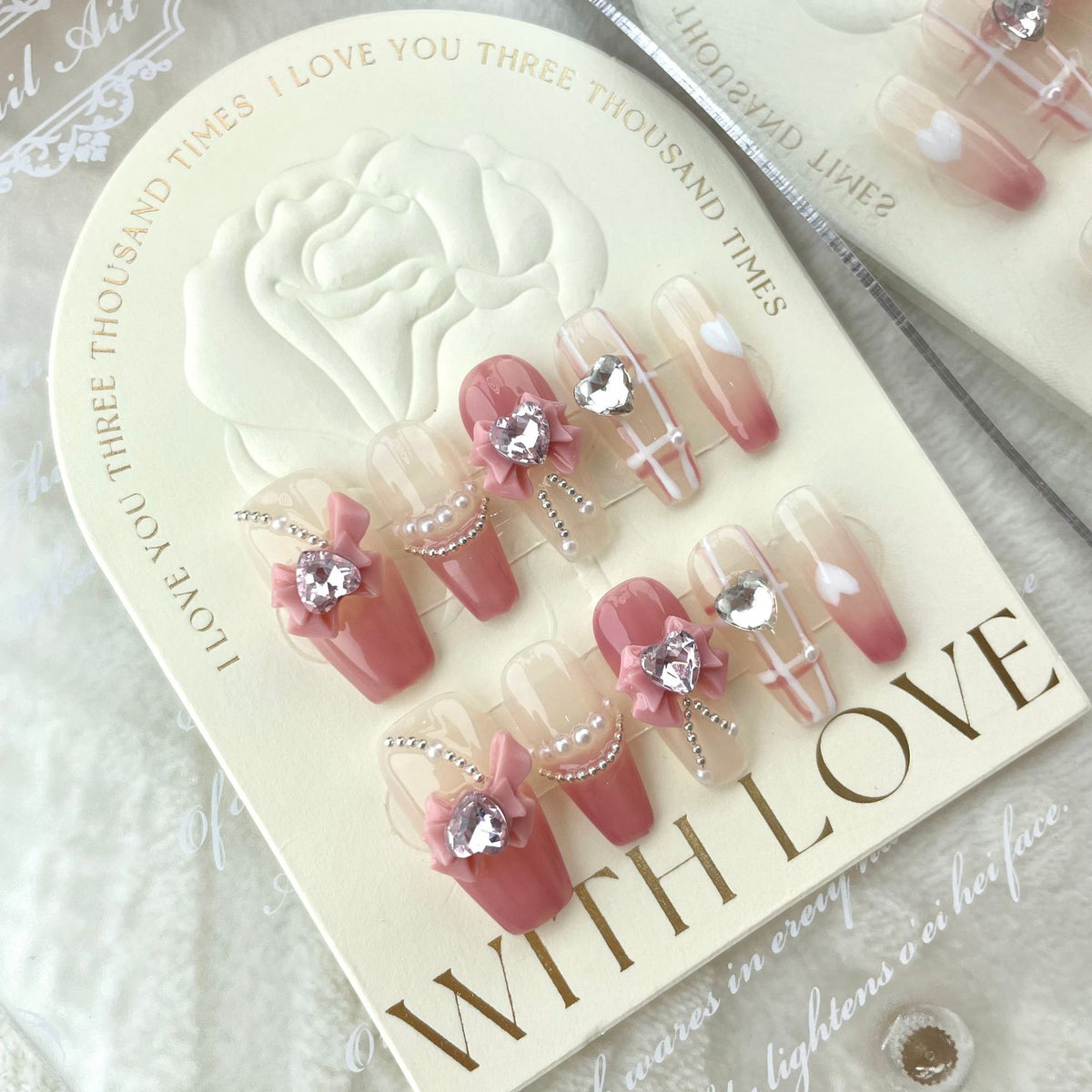 Pink bow press on nails with crystal heart charms and pearl details
