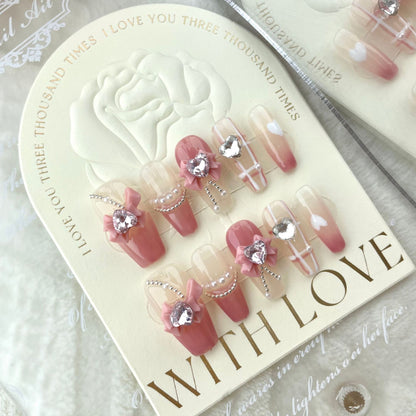 Pink bow press on nails with crystal heart charms and pearl details