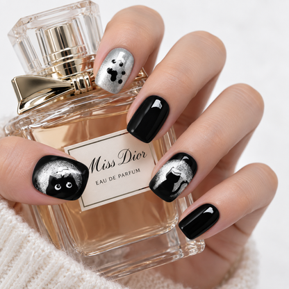 Black and silver cat press-on nails with glitter paw print designs