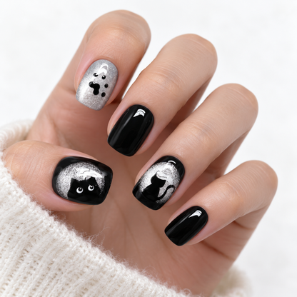 Black and silver cat press-on nails with paw prints and glitter details