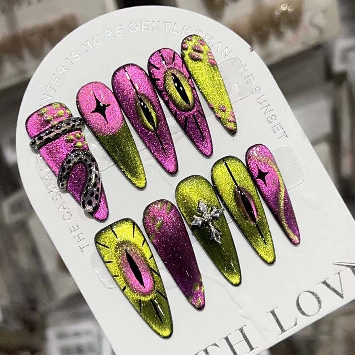 Handmade pink and green press-on nails with eye motifs, glitter and silver 3D nail charms