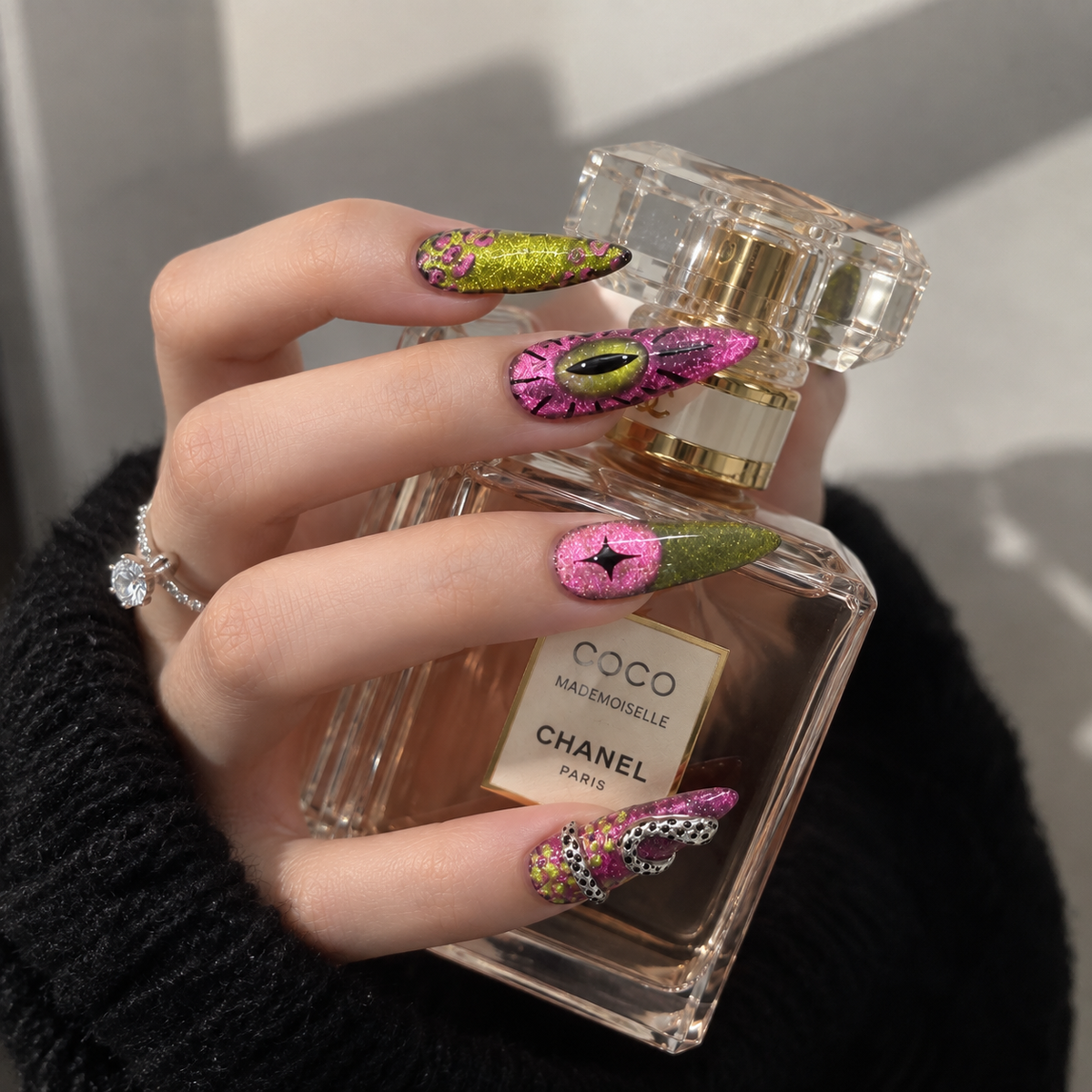 Luxury pink and green stiletto press-on nails with glitter eye designs and 3D embellishments
