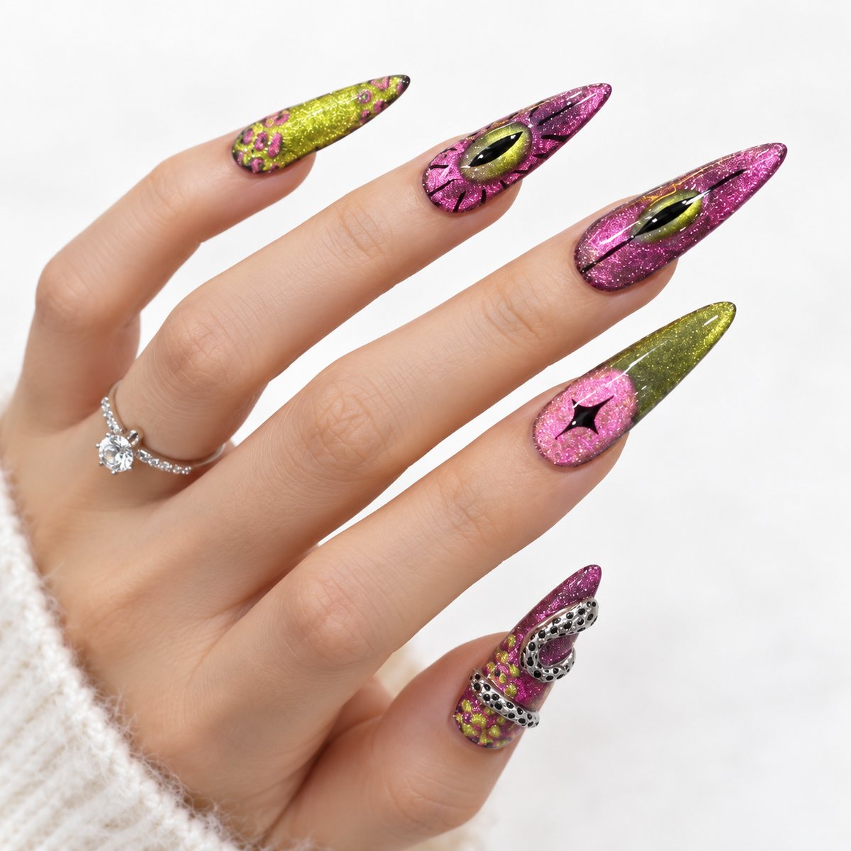 Pink and green stiletto press-on nails with glitter, eye designs and 3D silver details