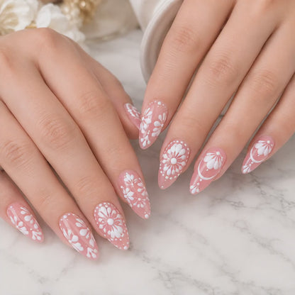 Pink floral almond press on nails worn on hand with white flower details