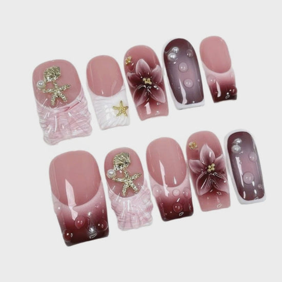 Pink Floral Ocean Press On Nails holding a luxury perfume bottle