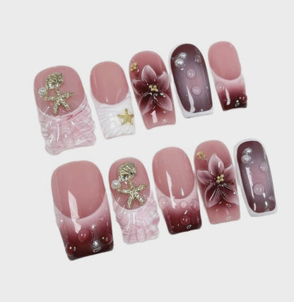 Pink Floral Ocean Press On Nails holding a luxury perfume bottle
