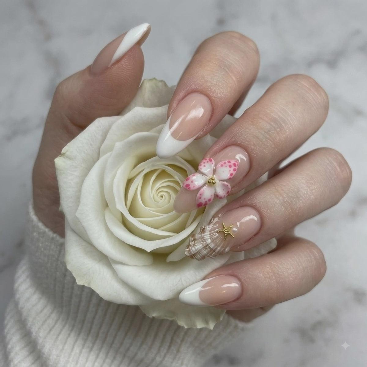 Pink 3D flower press on nails with crystal accents holding a white rose
