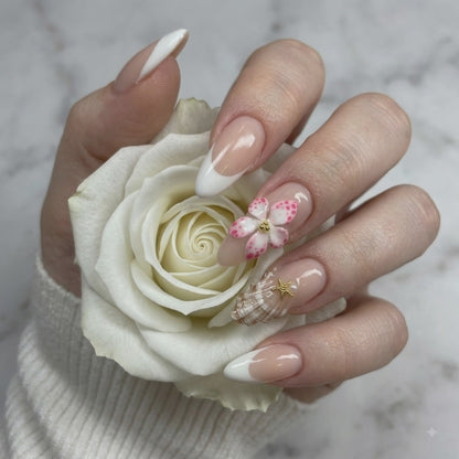 Pink 3D flower press on nails with crystal accents holding a white rose