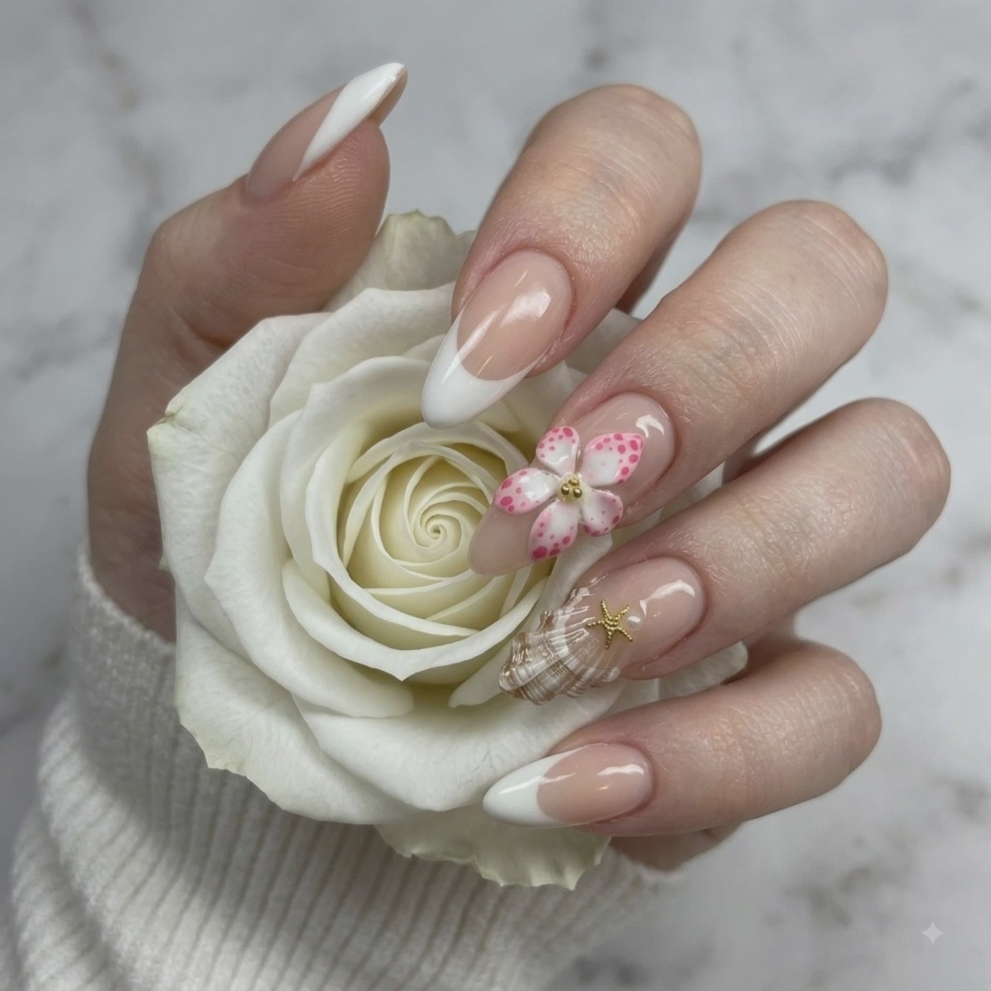 Pink 3D flower press on nails with crystal accents holding a white rose